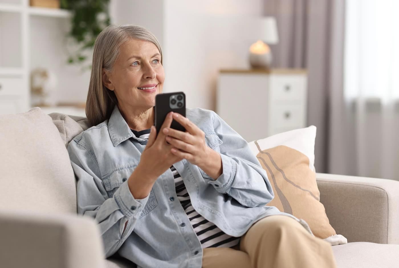 Mature woman smiling while using smartphone — Sequel blog