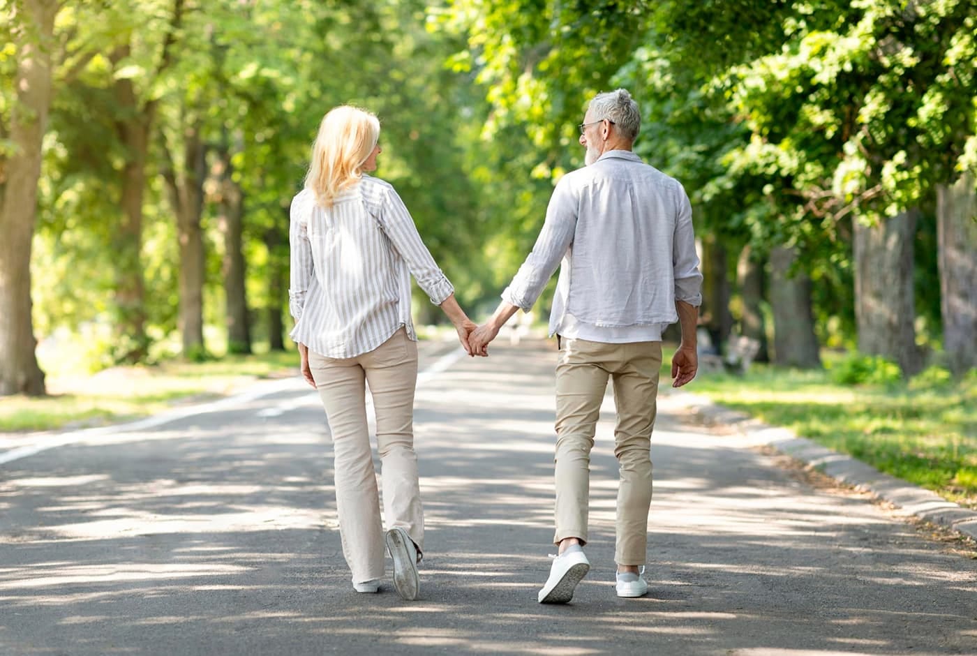 Older couple walking in the park holding hands